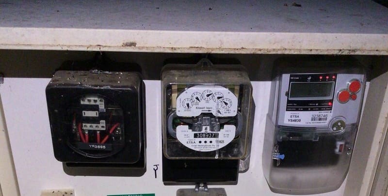 Picture of an electricity meter attached to the wall of a house.