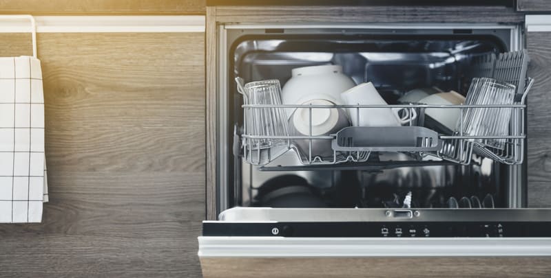 kitchen dishwasher loaded with clean plates, glasses and cutlery