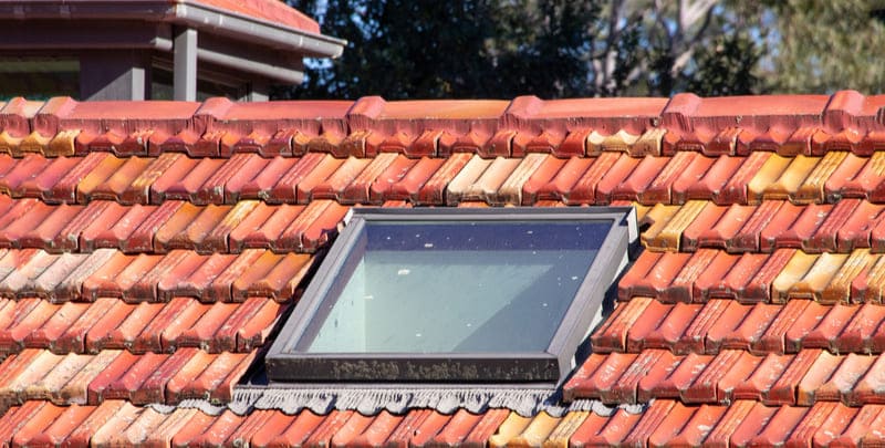 skylight installed on red tiled roof of a home