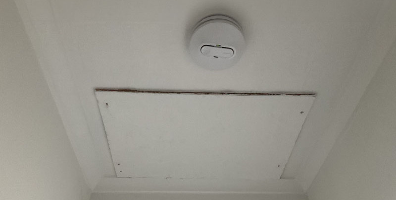 smoke alarm installed on ceiling next to roof entrance